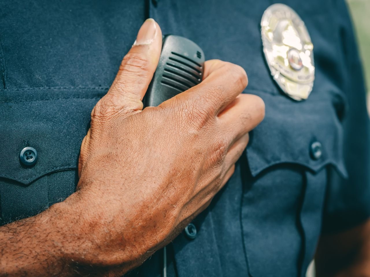 Crafting Captivating Headlines: Your awesome post title goes here A police officer in uniform holding a radio communicator, showcasing professional authority.